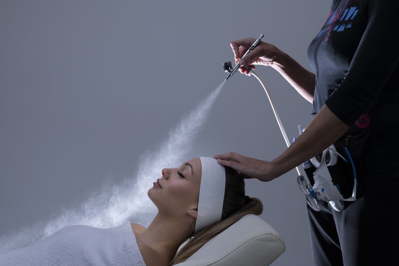 A fine oxygen infusion mist being applied to a guest's face