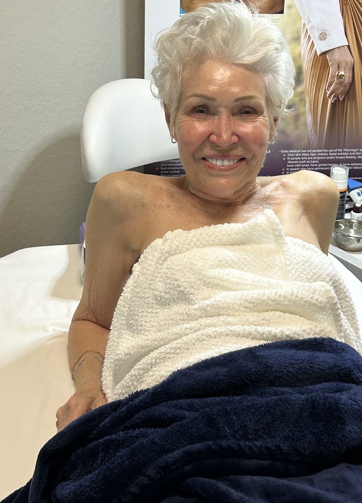 A smiling guest settled in for her Thermage FLX session